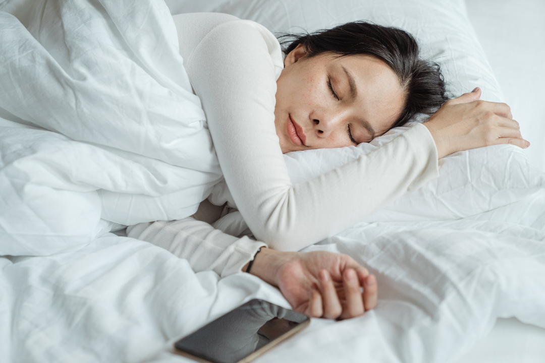 7 Simple Tips for Better Sleep That Actually Work Woman sleeping peacefully in white bedding demonstrating restful sleep from following tips for better sleep