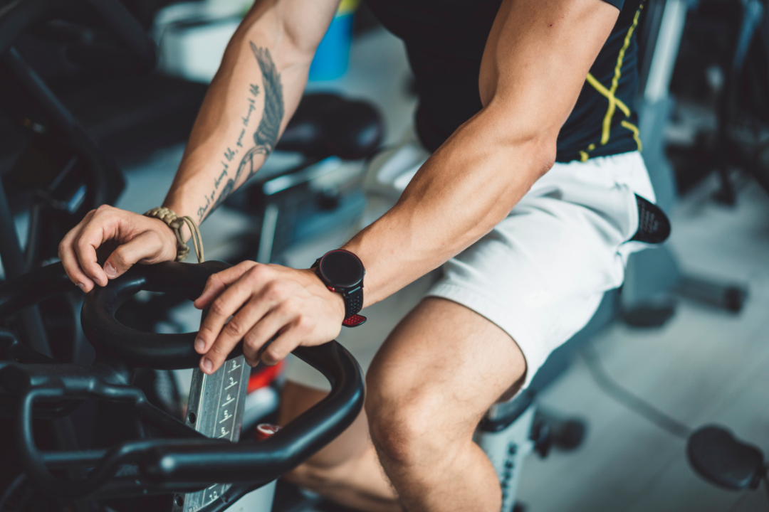 Man working out on a stationary bike, demonstrating effective tips for beginners starting a cardio workout routine.