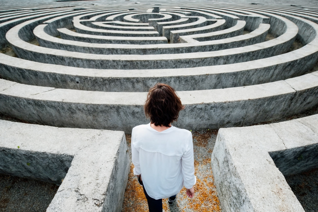 A person standing at the entrance of a large stone labyrinth, symbolising how SMART goals provide clear direction and progress through complex plans.
