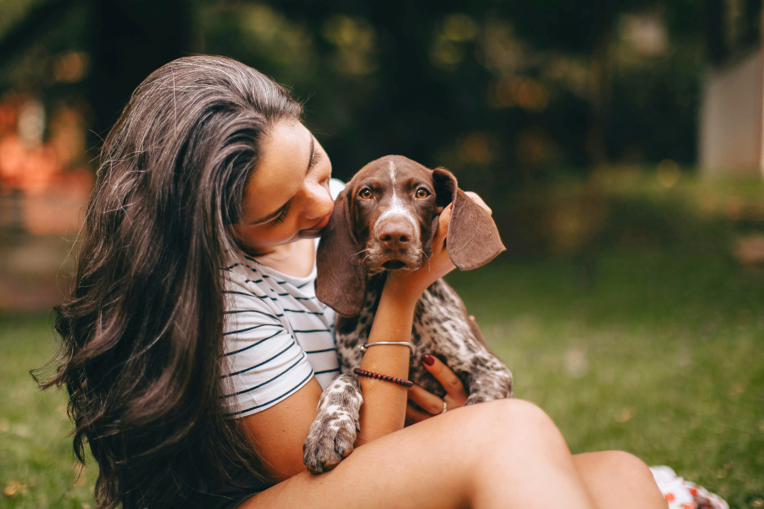 How to Find Your Passion: 7 Steps to Reconnect With What Lights You Up A woman sitting outdoors holding and smiling at her dog, symbolising joy, connection, and simple moments that help you find your passion.