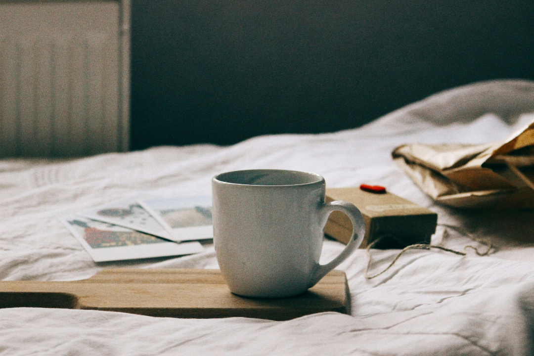 Social Media Took Over My Mornings Here's How I Got Them Back Peaceful morning bed scene with coffee mug, journal, and photos representing intentional morning routine free from social media addiction